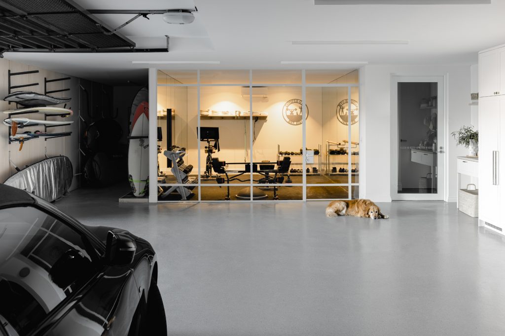 Darren-james-interiors-gold-coast-home-garage-with-gym-surfboards-and-a-dog
